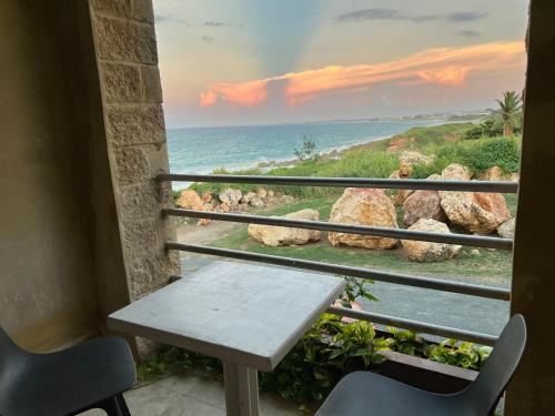 a table and chairs on a balcony looking out at the ocean at Vacation Rental Arecibo PR in Arecibo
