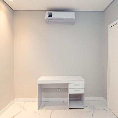a white desk in a room with a wall at M&M House - Casa com Piscina e Ar Condicionado em Matinhos in Matinhos