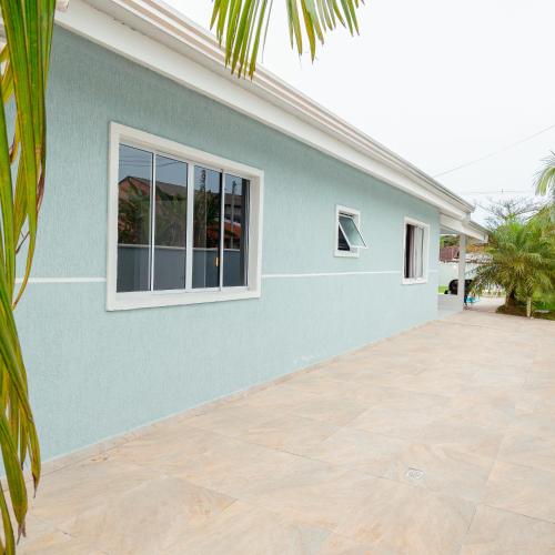 a house with a blue wall and a patio at M&M House - Casa com Piscina e Ar Condicionado em Matinhos in Matinhos