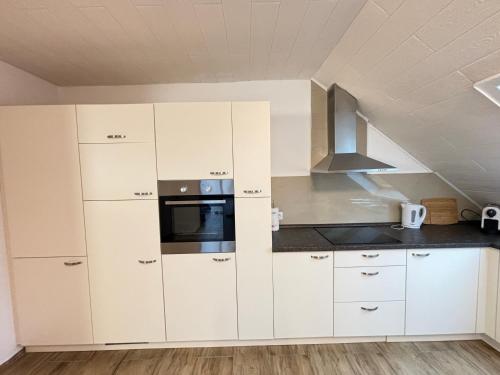 a kitchen with white cabinets and a microwave at XXL Penthouse - 240qm - 6 rooms - priv Parking- MalliBase Apartments in Garbsen