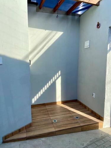 a room with a white wall and a wooden floor at Loft Iron em capim macio in Natal