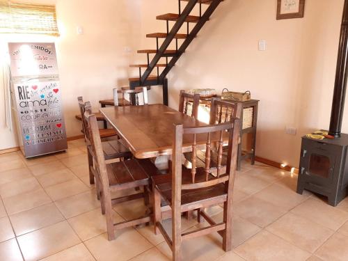 a dining room with a wooden table and chairs at Ventura apart in Estancia Vieja