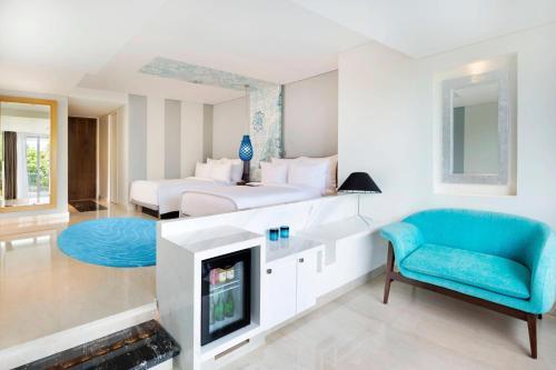 a living room with a bed and a fireplace at Le Meridien Bali Jimbaran in Jimbaran