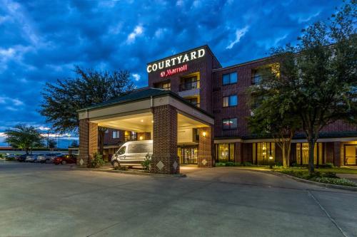 a hotel with a van parked in front of it at Courtyard Dallas DFW Airport South/Irving in Irving