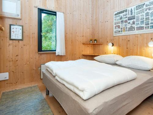 a bedroom with two beds in a wooden wall at Charming Retreat by River - By Traum Ferienwohnungen in Fårvang