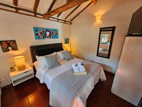 una camera da letto con un letto con due asciugamani sopra di Casita Artemisa - Tiny House Romántica y Mágica a Villa de Leyva