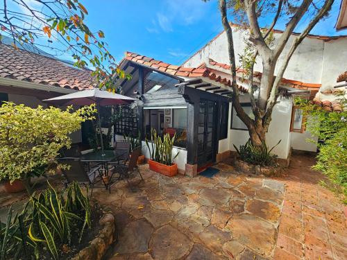 una casa con patio con tavolo e ombrellone di Casita Artemisa - Tiny House Romántica y Mágica a Villa de Leyva