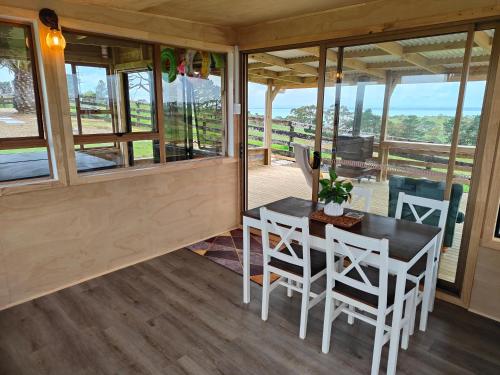 a dining room with a table and chairs and windows at Apartment 1 in Auckland