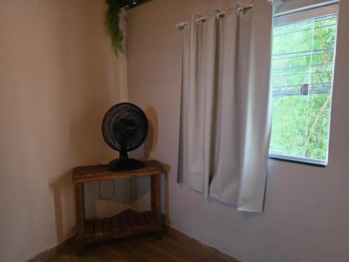 a room with a white curtain and a fan at Pousada Piu-piuu Cajazeiras in Salvador
