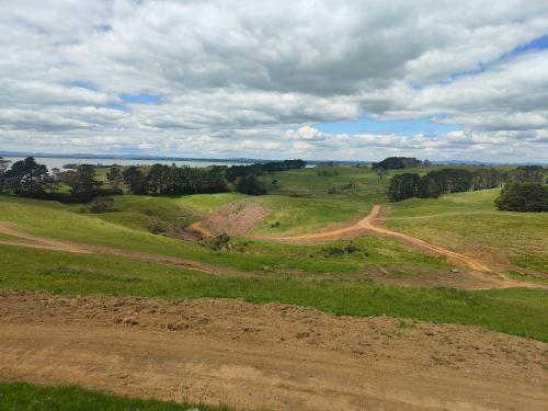 an open field with a dirt road in the distance at Apartment 1 in Auckland