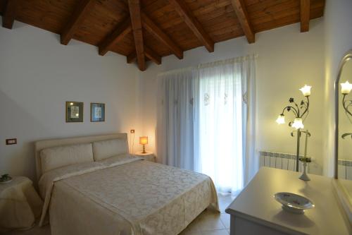 a bedroom with a bed and a large window at Nit i Dia Guest House in Alghero