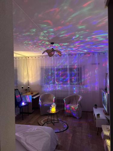 a room with a ceiling with purple and pink lights at Appartement Relaxe in Carquefou