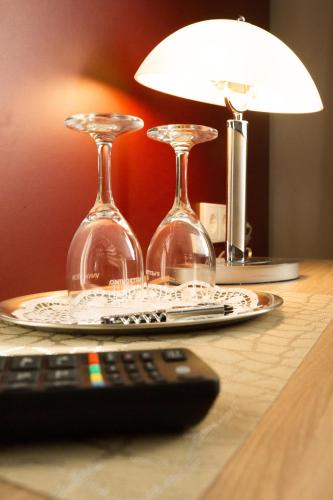 a table with two wine glasses and a remote control at Hotel Löhr in Baden-Baden