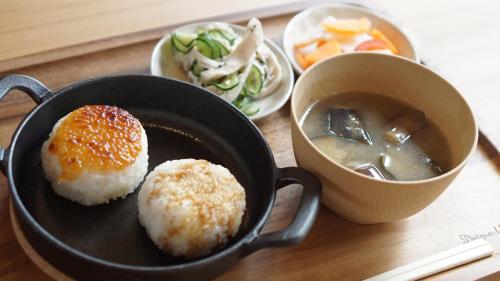 a frying pan with sushi and a bowl of soup at Farm Stay Ezura Farm in Engaru