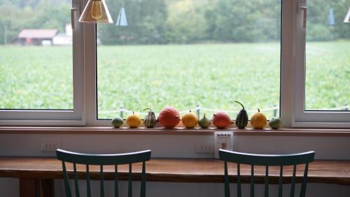 a table with fruits and vegetables on a window sill at Farm Stay Ezura Farm in Engaru