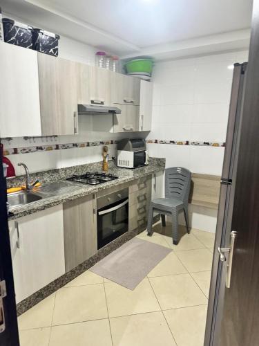 una cocina con fregadero y estufa horno superior en Appartement résidence rivaldi, en Jbila