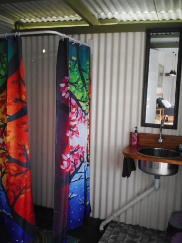 a bathroom with a shower curtain and a sink at The Studio at Gingerbread in Savusavu