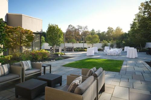 a patio with couches and tables with white table settings at Hanover Marriott in Whippany