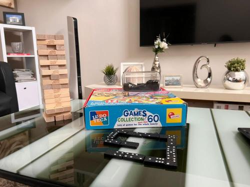 a box of games on a glass table at Accra Cozy Retreat with 2 Bedrooms in Accra