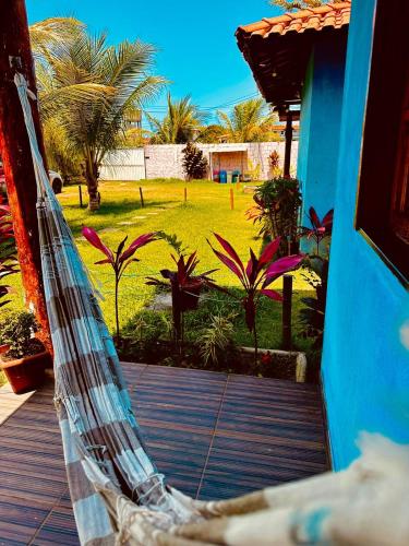 a hammock on a porch with a yard with palm trees at Vila Itacimirim in Itacimirim