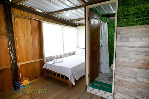 a bedroom with a bed in a room with a window at Villa Inesita in Panguí