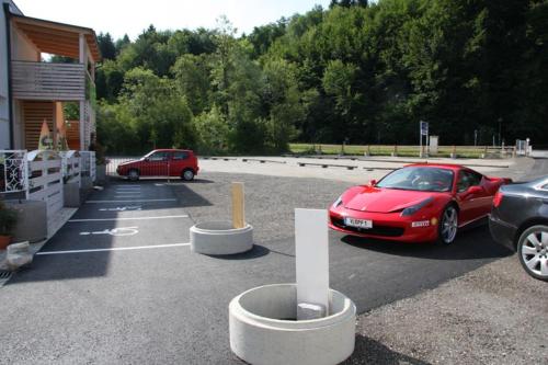 a red car is parked in a parking lot at Waldschlössl in Latschach ober dem Faakersee