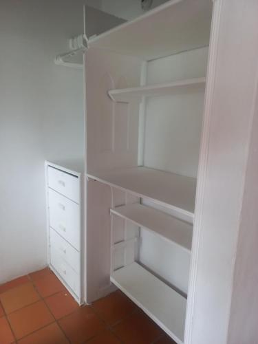 a white closet with white shelves and a floor at Hotel Villa Paz in Villa de Leyva