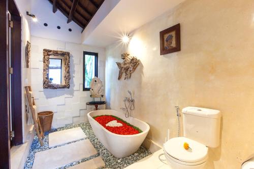a bathroom with a bath tub filled with red gravel at Villa Chantal-Intimate Villa in Seminyak in Seminyak