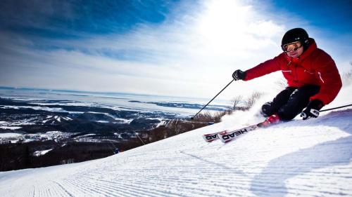 a man is skiing down a snow covered slope at Les Suites des Chutes - La Royale in Boischâtel