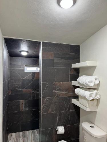a bathroom with a shower and a toilet and towels at El descanso casa-hotel zacatlán. in Zacatlán