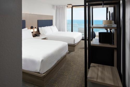 a hotel room with two beds and a view of the ocean at Four Points by Sheraton Virginia Beach Oceanfront in Virginia Beach