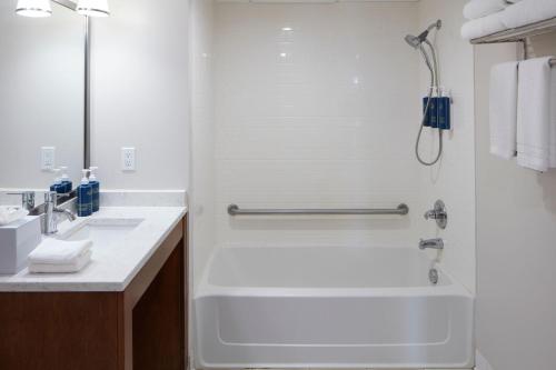 a bathroom with a bathtub and a sink at Four Points by Sheraton Virginia Beach Oceanfront in Virginia Beach