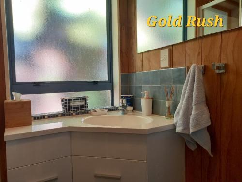 a bathroom with a sink and a window with the words gold rush at Charleston Goldfields Accommodation in Charleston