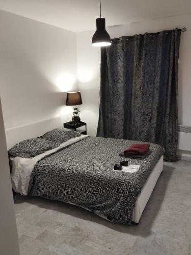 une chambre avec un lit, une lampe et une fenêtre dans l'établissement Chez Stf, à Sanary-sur-Mer