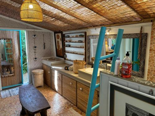 a bathroom with a sink and a mirror at French Polynesia Secret House avec jacuzzi et piscine partagée in Moorea
