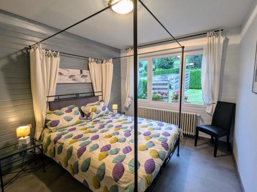 une chambre avec un lit à baldaquin et une fenêtre dans l'établissement Gîte à Gérardmer : sauna, terrasse, proche lac et stations de ski - FR-1-589-669, à Gérardmer