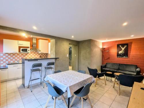 une cuisine et un salon avec une table et des chaises dans l'établissement Gîte cosy au cœur de Gérardmer avec jardin et terrasse - FR-1-589-670, à Gérardmer