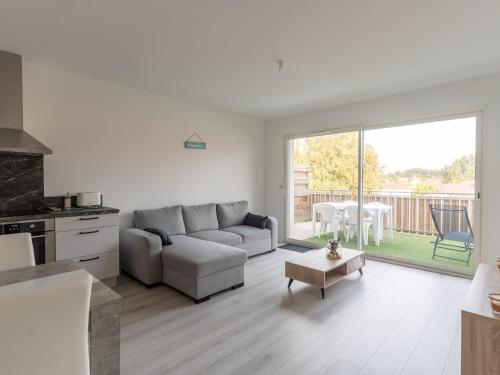 un salon avec un canapé et une table dans l'établissement Appartement 4 pers. centre Mimizan, neuf avec parking - FR-1-50-143, à Mimizan