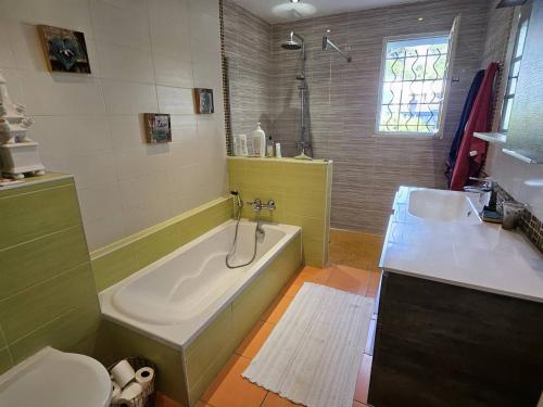 une salle de bain avec une baignoire, des toilettes et un lavabo dans l'établissement Villa charmante avec piscine, clim, wifi et parking à 300m de la mer - FR-1-768-107, aux Issambres
