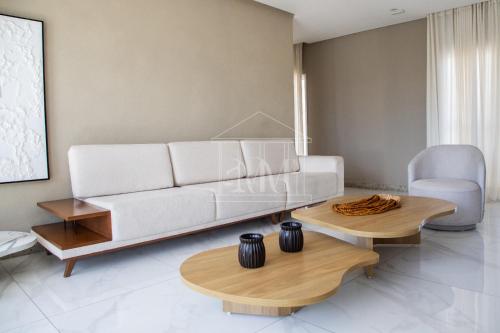 a living room with a white couch and two tables at Studio Completo a Beira Mar, Grand Smart Residence in Aracaju