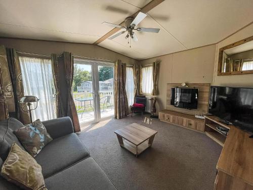 a living room with a couch and a tv at 4 Berth Caravan With Decking And Wifi At Carlton Meres In Suffolk Ref 60010K in Saxmundham