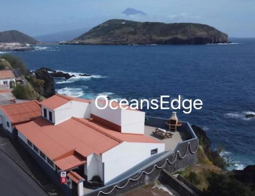 a building with the words oceans edge next to the ocean at Ocean's Edge in Horta