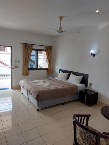 a bedroom with a bed and a window and a chair at Smile house in Karon Beach
