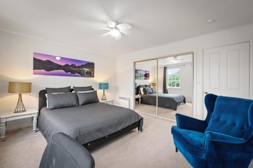 a bedroom with a bed and a blue chair at Hobart City Townhouse in Hobart