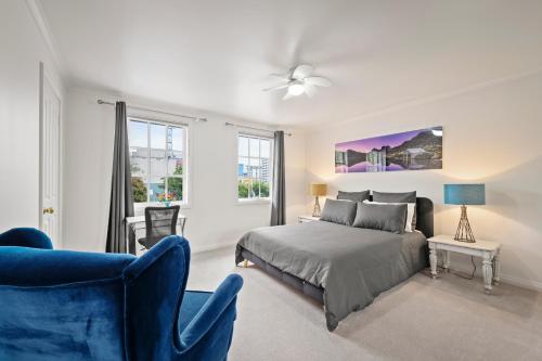 a bedroom with a bed and a blue chair at Hobart City Townhouse in Hobart