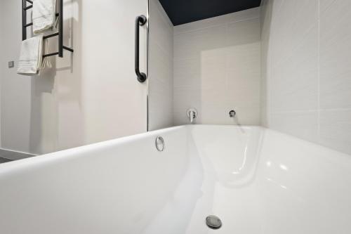 a white bath tub in a white bathroom at Hobart City Townhouse in Hobart