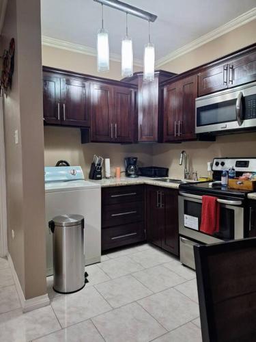 a kitchen with wooden cabinets and a stove top oven at Chateau Central at Sunbury Apts in Kingston