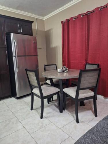 a kitchen with a table and chairs and a refrigerator at Chateau Central at Sunbury Apts in Kingston