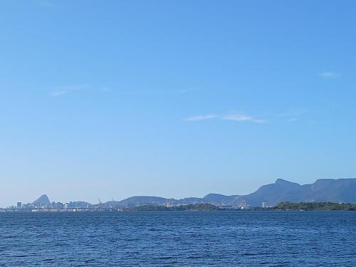 a large body of water with mountains in the background at Quarto Privado Cama Casal e Individuais Apto in Rio de Janeiro