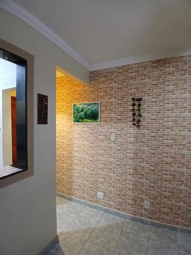 a room with a brick wall with a painting on it at Quarto Privado Cama Casal e Individuais Apto in Rio de Janeiro